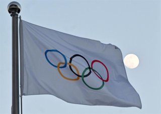 Archivo - FILED - 14 February 2022, China, Peking: The moon can be seen behind the flag with the Olympic rings. One year before the start of the Olympic Games in Paris, the European Consumer Centre Germany (ECC) has advised fans not to wait too long when 