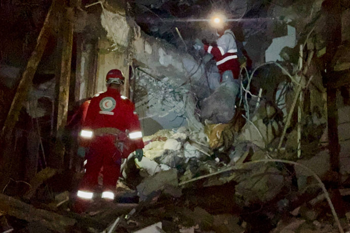09 March 2026, Iran, Teheran: Members of the Iranian Red Crescent Society (IRCS) rescue teams work at the site of a building damaged in a US-Israeli airstrike on Tehran. Photo: Ircs/ZUMA Press Wire/dpa