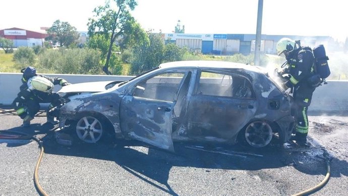 Los bomberos durante su intervención para apagar un coche incendiado en la autopista de Inca.