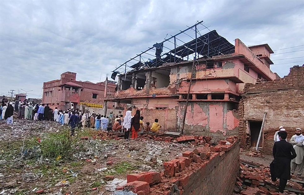Varias personas se congregan cerca de un edificio dañado por una ataque suicida en el distrito de Bannu, en en el noroeste de Pakistán