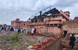 BANNU, April 3, 2026  -- People gather near a building damaged in a blast in Bannu district of Pakistan's northwestern Khyber Pakhtunkhwa province, April 3, 2026. At least five civilians were killed and several others, including two police personnel, were