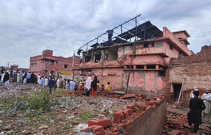 BANNU, April 3, 2026  -- People gather near a building damaged in a blast in Bannu district of Pakistan's northwestern Khyber Pakhtunkhwa province, April 3, 2026. At least five civilians were killed and several others, including two police personnel, were