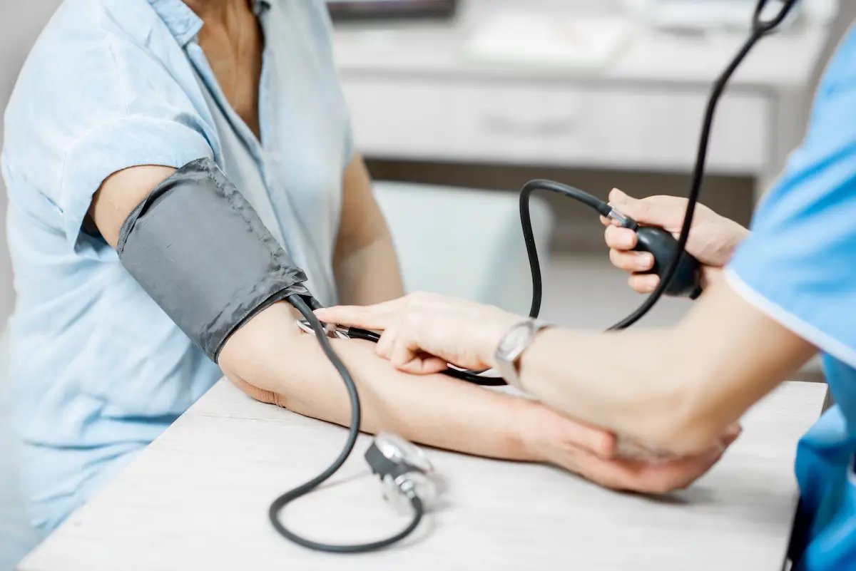 Enfermera midiendo la presión arterial de una paciente de edad avanzada