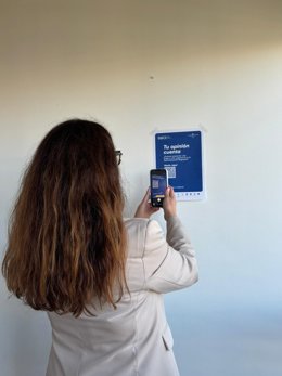 Una Ciudadana, Haciendo Uso De Los Códigos QR Instalados Para Sustituir Los Buzones Físicos