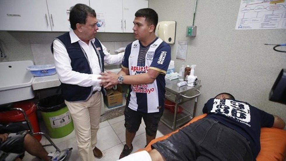 El ministro de Salud de Perú, Juan Carlos Velasco, con aficionados del Alianza Lima afectados por un tumulto