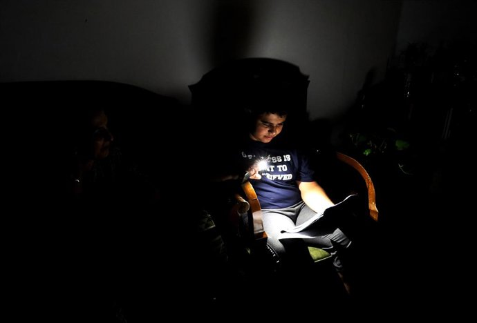 Archivo - BAGHDAD, Aug. 11, 2025  -- A boy reads in the darkness after a power outage in Baghdad, Iraq, on Aug. 11, 2025. A sudden failure in Iraq's power transmission lines on Monday triggered a nationwide blackout, the Electricity Ministry said.