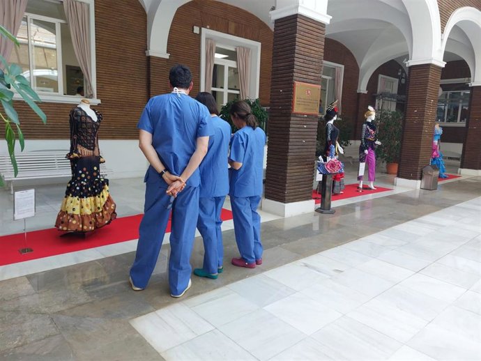 Sanitarios observando la exposición 'Sevilla y olé. Visita Sevilla en sus trajes típicos'.