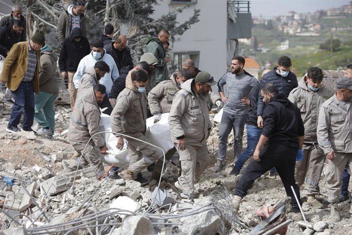 Un grupo de personas entre los escombros tras el bombardeo de Israel a una vivienda cerca de Sidón, en el sur de Líbano