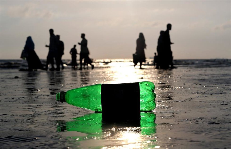 Archivo - 03 July 2023, Bangladesh, Chattogram: A plastic bottle is thrown on the sand while people walk at Parki Beach. Locals along Parky Beach, as well as tourists and beach food vendors, have added to the pollution. No initiative has been taken by the