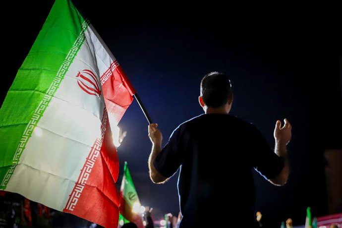 Un hombra ondea la bandera de Irán en una manifestación en favor del régimen