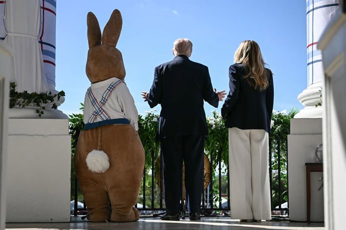 April 6, 2026, Washington, District Of Columbia, USA: US President Donald Trump and First Lady Melania Trump stand next to a constumed Easter bunny as they address the crowd from the balcony during the annual Easter Egg Roll on the South Lawn of the White