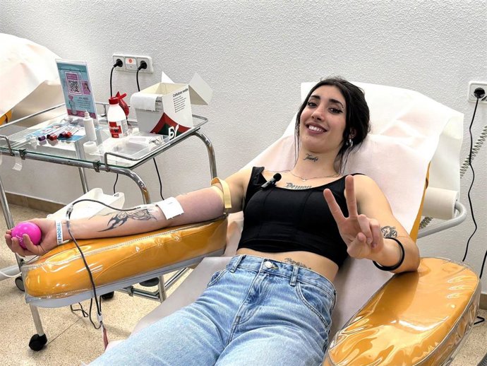 Una mujer dona sangre.