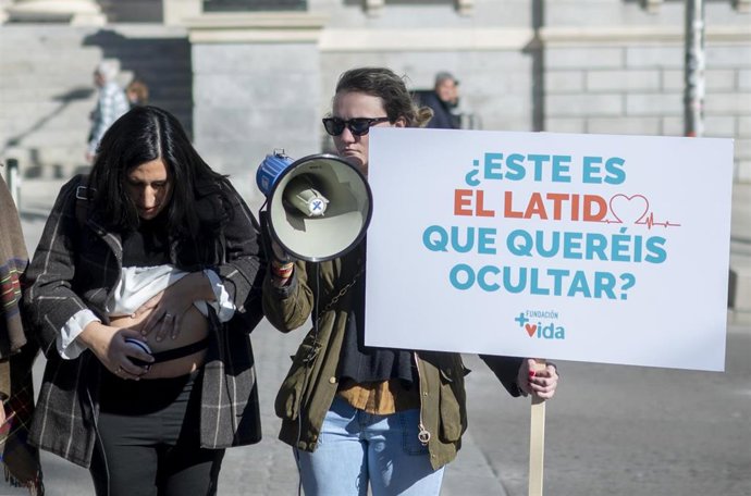 Archivo - Dos jóvenes pertenecientes a Fundación +Vida, con pancartas frente al Congreso a 16 de febrero de 2023, en Madrid.