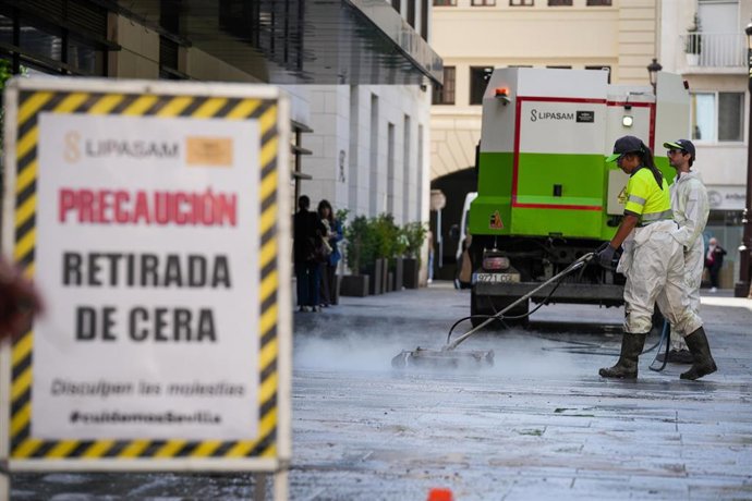 Operarios de Lipasam retiran la cera acumulada en el pavimento de la Plaza de la Magdalena tras el paso de las cofradías de la Semana Santa.