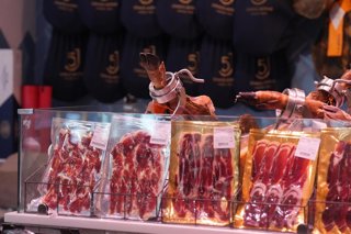 Archivo - Jamón serrano expuestos en un mercado en Barcelona.