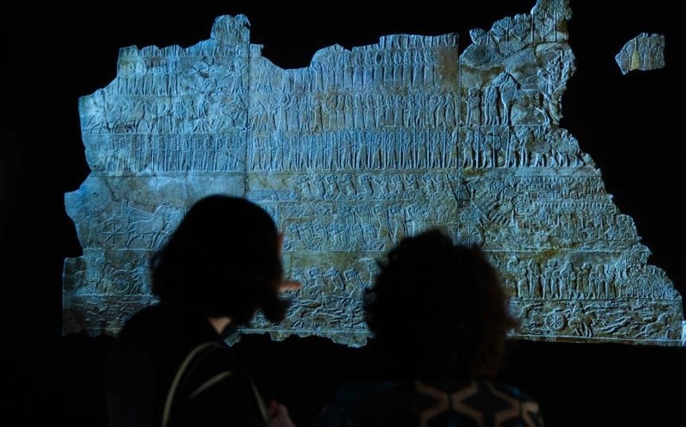 Dos visitantes admiran una de las piezas presentes en la exposición Asurbanipal en CaixaForum Madrid.
