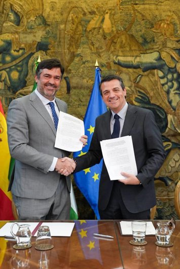 Juan García Liñán y José María Bellido se dan la mano tras la firma del contrato.