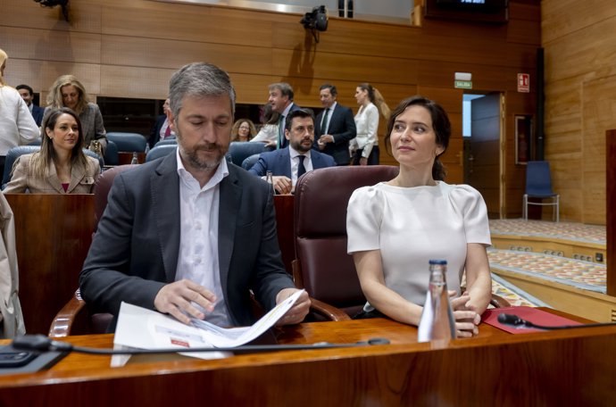 La presidenta de la Comunidad de Madrid, Isabel Díaz Ayuso (d), y el consejero de Presidencia, Justicia y Administración Local, y portavoz del Gobierno autonómico, Miguel Ángel García Martín (I), durante el Pleno de la Asamblea de Madrid, a 9 de abril 