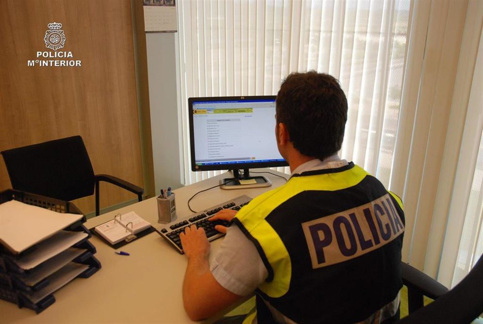 Archivo - Agente de Policía Nacional delante de un ordenador
