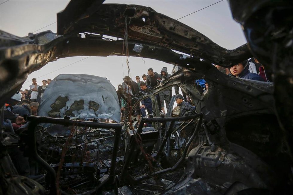 Un grupo de personas frente a los restos de un vehículo bombardeado por Israel en la Franja de Gaza (archivo)
