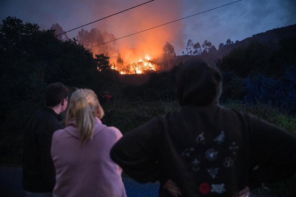 Varias personas observan el incendio forestal en el monte Galleiro, a 6 de abril de 2026, en Ribadetea, Ponteareas, Pontevedra, Galicia (España). El incendio de monte Galleiro comenzó a las 14:47 horas en la parroquia de Ribadetea, en el municipio de Pont