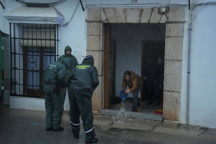Archivo - Un vecino se afana en achicar agua de su vivienda inundada en localidad gaditana de Grazalema tras el paso de la borrasca Leonardo.