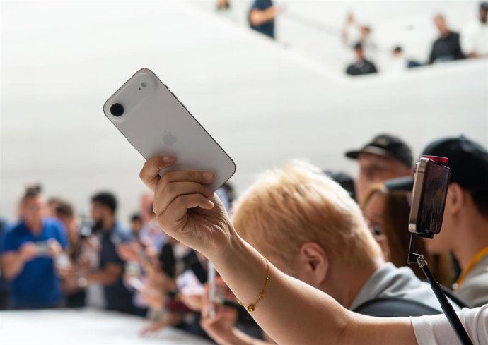 Archivo - 09 September 2025, US, Cupertino: A participant at the presentation of new iPhone models from Apple tries out the new thinner iPhone Air. Photo: Andrej Sokolow/dpa