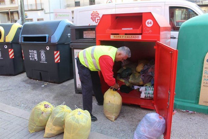 Archivo - Un trabajador de Recuperaciones Redoble recoge ropa de un contenedor de Cáritas en Jaén.