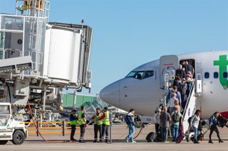 Archivo - Un avión de la compañía Transavia estacionado junto a uno de los fingers del aeropuerto sevillano.
