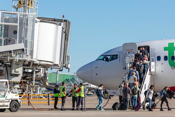 Archivo - Un avión de la compañía Transavia estacionado junto a uno de los fingers del aeropuerto sevillano.