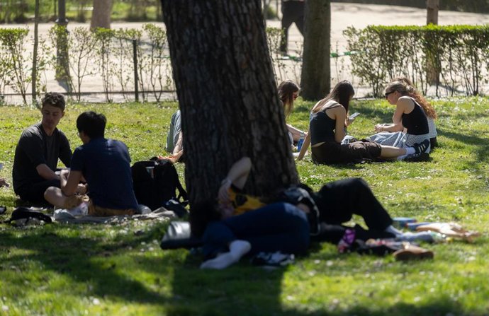 Un grupo de personas sentadas en el césped de un parque, a 17 de marzo de 2026, en Madrid (España). 