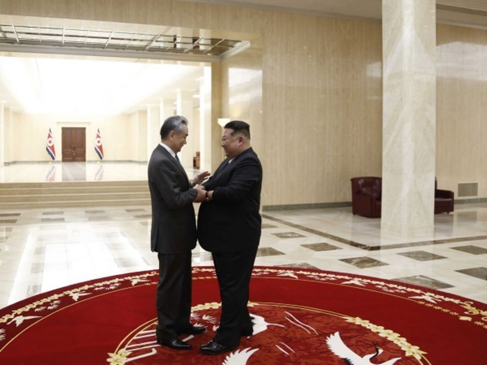 El líder norocoreano, Kim Jong Un (D), y el ministro de Exteriores chino, Wang Yi (I)