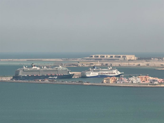 Archivo - DOHA, March 6, 2026  -- This photo taken with a mobile phone shows the Mein Schiff 5 (L) in Doha, Qatar, March 6, 2026. The Mein Schiff 5, operated by German-based travel company TUI, completed its sailing on Feb. 28 and was docked at the port o