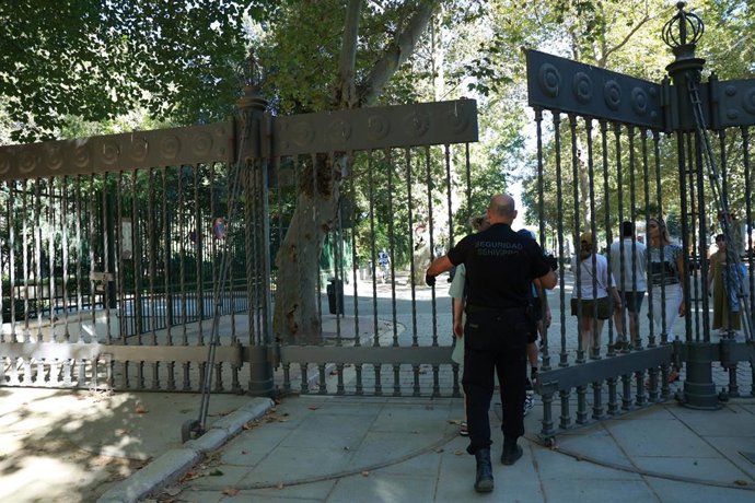 Archivo - Un empleado de seguridad cierra la puerta de acceso al parque de María Luisa. A 11 de septiembre de 2025, en Sevilla (Andalucía, España). 