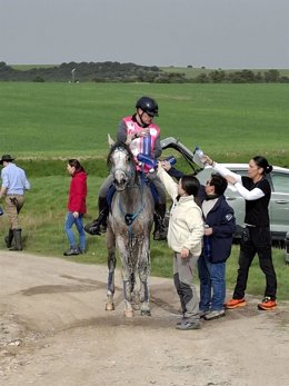 Varios asistentes proporcionan agua a un jinete y a su caballo en un punto de asistencia durante el XI Raid Ecuestre de Villacastín.