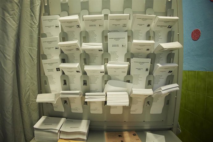 Archivo - Imagen de archivo de una cabina de votación repleta de papeletas de los partidos.