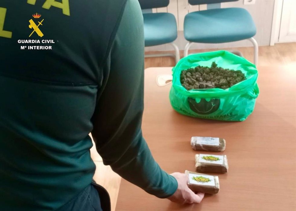 Un agente de la Guardia Civil junto a la droga intervenida en Oliva de Plasencia.E