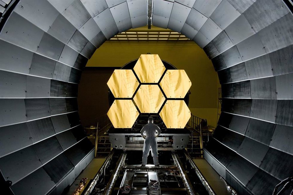 Imagen tomada en 2011 del ingeniero de la NASA Ernie Wright observando cómo se preparan los seis primeros segmentos del espejo principal del Telescopio Espacial James Webb, listos para el vuelo.