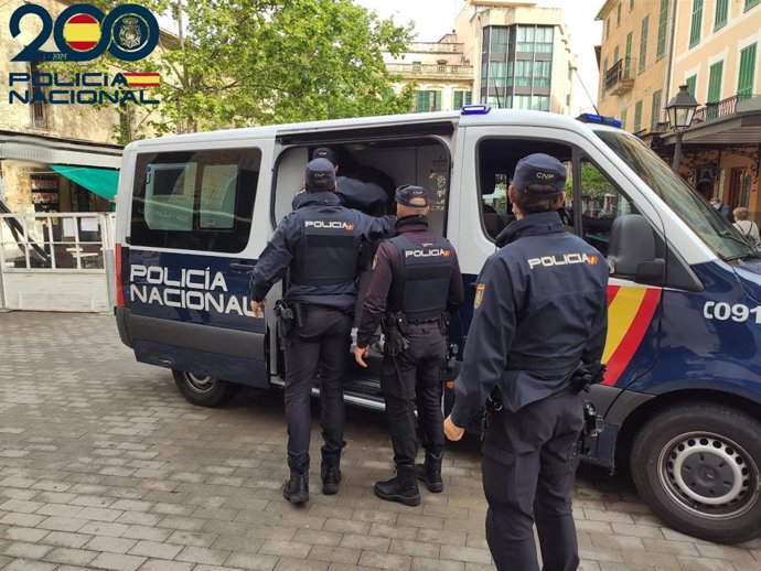 Los agentes conducen a los detenidos en un vehículo policial.