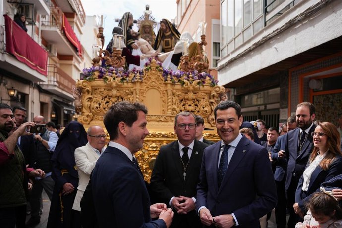 El presidente de la Junta de Andalucía, Juanma Moreno (d), ante el paso de la Virgen de La Piedad, durante la visita institucional al municipio de Cabra. (Foto de archivo).