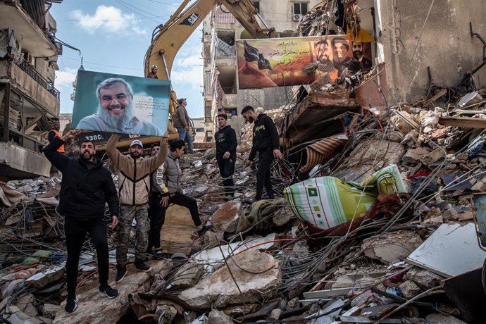 10 de abril de 2026, Líbano: Apoiadores do Hezbollah seguram uma foto do secretário-geral assassinado Hassan Nasrallah em Hey al-Soulom, nos subúrbios do sul de Beirute, onde as buscas por corpos ainda estavam em andamento dois dias após um ataque aéreo a