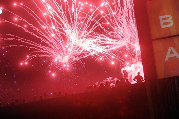 Archivo - Varias personas contemplan los fuegos artificiales de San Fermín desde la terraza de Baluarte.