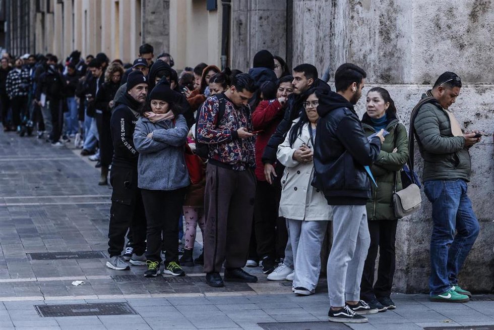 Archivo - Decenas de inmigrantes hacen cola en el Ayuntamiento de Valencia.