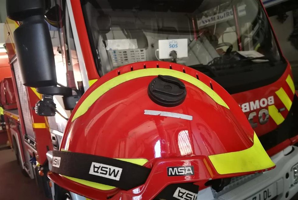 Archivo - Imagen de autobomba y casco de bombero.