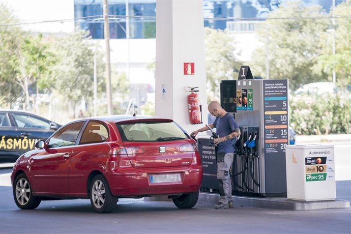 Archivo - Una persona reposta en una gasolinera.