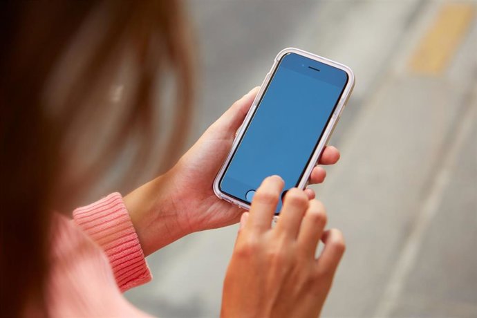 Archivo - Una joven con su teléfono