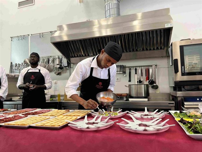 Una persona migrante trabaja en una cocina.