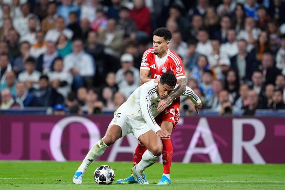 El inglés Jude Bellingham (Real Madrid) protege el balón ante el colombiano Luis Díaz (Bayern) en la Champions 2025-26. 