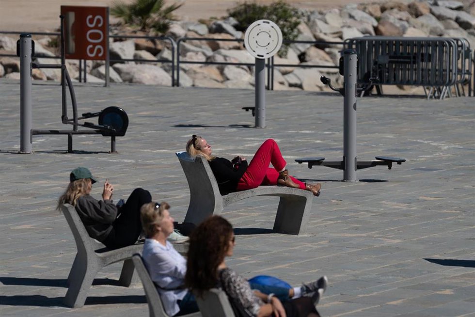 Archivo - Varias personas toman el sol en el paseo marítimo de la playa del Bogatell, a 15 de abril de 2024, en Barcelona, Catalunya (España). 