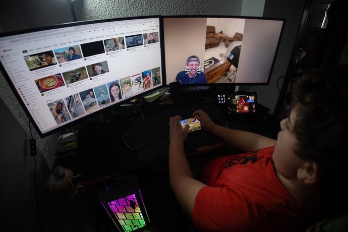 Archivo - Un niño mientras observa varias pantallas, a 20 de enero de 2025, en Madrid (España).